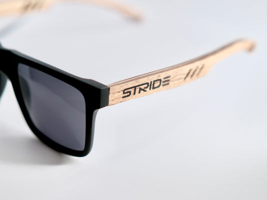 A pair of rectangular-framed sunglasses with polarized lenses and bamboo-style temples, featuring the brand name 'STRIDE' on the side.